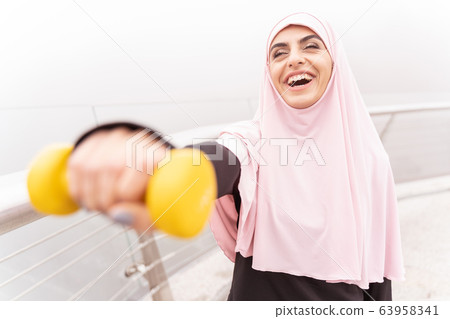 Excited woman exercising with hand weight stock photo Excited woman exercising with hand weight stock photo 63958341