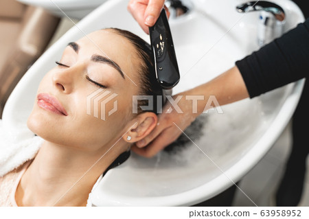 Attractive brunette girl enjoying beauty procedures in salon Attractive brunette girl enjoying beauty procedures in salon 63958952