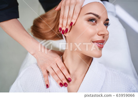 Smiling woman during face massage stock photo Smiling woman during face massage stock photo 63959066