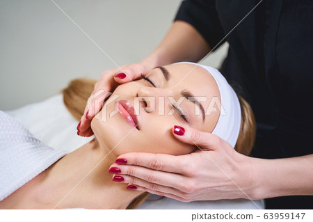 Young woman during face massage stock photo Young woman during face massage stock photo 63959147
