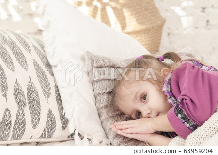 little smiling three year old girl is lying on the 63959204
