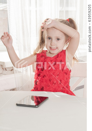little girl in a red dress sits at a table and little girl in a red dress sits at a table and 63959205
