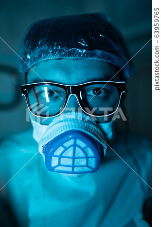 Young male researcher carrying out scientific experiment. Young male researcher carrying out scientific experiment. 63959765