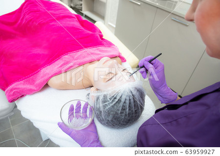 Face peeling mask, spa beauty treatment, skincare. Woman getting facial care by beautician at spa salon Face peeling mask, spa beauty treatment, skincare. Woman getting facial care by beautician at spa salon 63959927