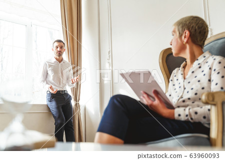 Senior woman psychotherapist sitting in an armchair 63960093