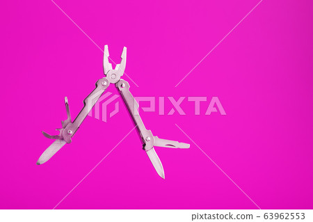Multitool is a multi-functional tool on a pink Multitool is a multi-functional tool on a pink 63962553