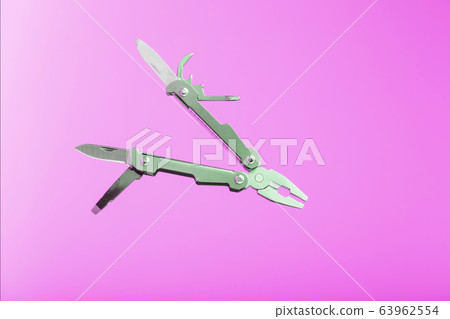 Multitool is a multi-functional tool on a pink Multitool is a multi-functional tool on a pink 63962554