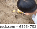 Play in the sandbox with a toy bulldozer 63964752