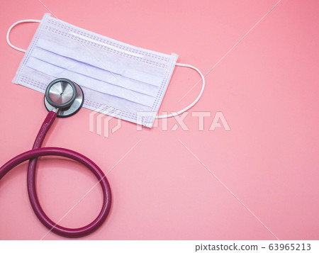 mask and stethoscope placed on a pink background 63965213