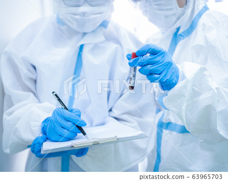 Woman doctor wearing mask and holding test tube 63965703