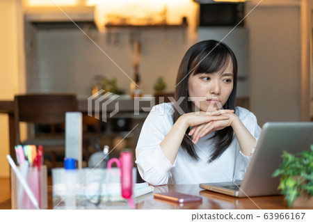 晚上在家工作的年輕女子 63966167