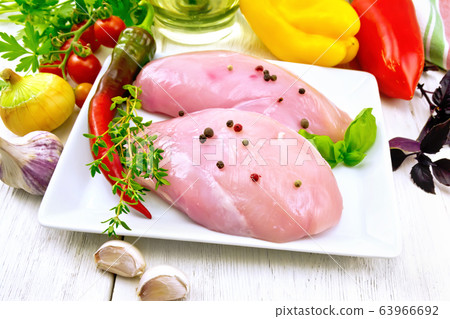 Chicken breast raw in plate with vegetables 63966692