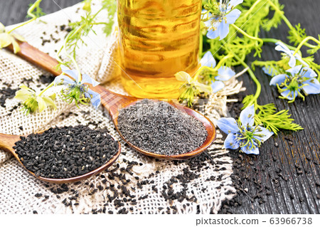 Flour and seeds of kalingi in spoons on old board Flour and seeds of kalingi in spoons on old board 63966738