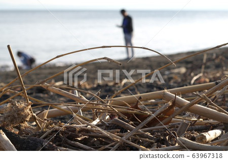 There is a person far beyond the straw being launched on the shore 63967318