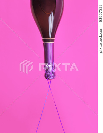 Champagne bottle upside down floats on bold color Champagne bottle upside down floats on bold color 63967532