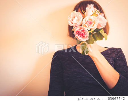 Faceless female portrait with flowers covering her face 63967542
