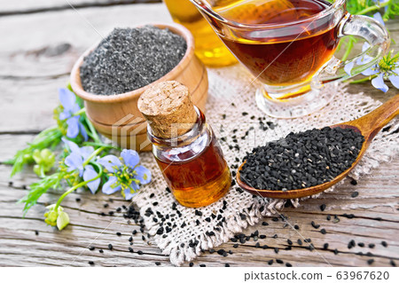 Oil kalingi in bottles and gravy boat on old board Oil kalingi in bottles and gravy boat on old board 63967620