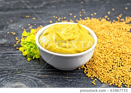 Sauce mustard in bowl with seeds and flower Sauce mustard in bowl with seeds and flower 63967735