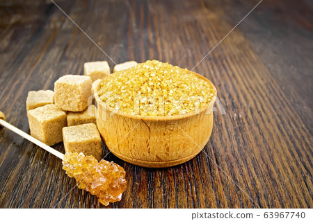 Sugar brown in bowl on dark wooden board Sugar brown in bowl on dark wooden board 63967740