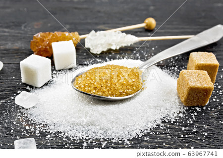 Sugar brown in spoon and white on board Sugar brown in spoon and white on board 63967741
