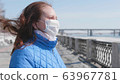 A girl in a protective mask on the street. Prevention and protection of health and safety of life. Coronavirus N1H1, covid-19, pandemic in the world. 63967781