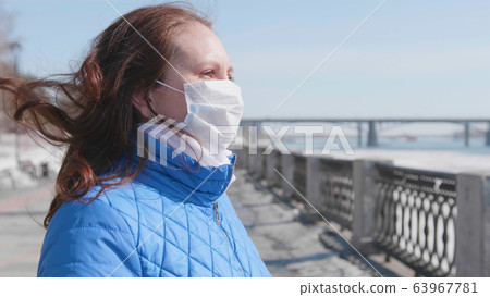 A girl in a protective mask on the street. Prevention and protection of health and safety of life. Coronavirus N1H1, covid-19, pandemic in the world. 63967781