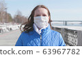 A girl in a protective mask on the street. Prevention and protection of health and safety of life. Coronavirus N1H1, covid-19, pandemic in the world. 63967782
