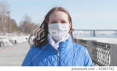 A girl in a protective mask on the street. Prevention and protection of health and safety of life. Coronavirus N1H1, covid-19, pandemic in the world. 63967782