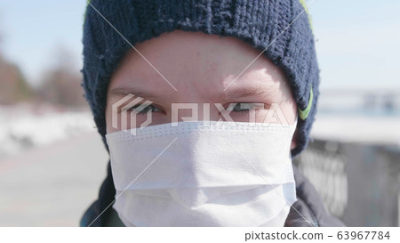 Guy in a protective mask on the street. Prevention and protection of health and life safety. Coronavirus N1H1,covid-19, a pandemic in the world. Guy in a protective mask on the street. Prevention and protection of health and life safety. Coronavirus N1H1,covid-19, a pandemic in the world. 63967784