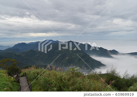 靛藍的藍天，綠樹，白色，茂密的多雲山脈。 63969919