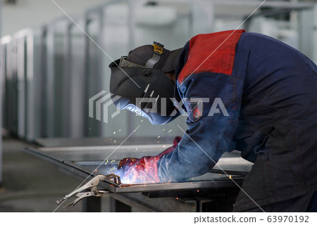 Welder working on factory, Welding Work. Erecting Technical Steel Industrial Craftsman on plant. 63970192