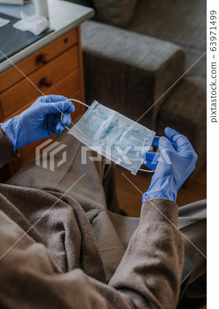 Senior holding protective mask in his hands Senior holding protective mask in his hands 63971499