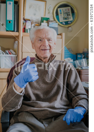 Old man wearing Protective Gloves against Covid-19 Old man wearing Protective Gloves against Covid-19 63971584
