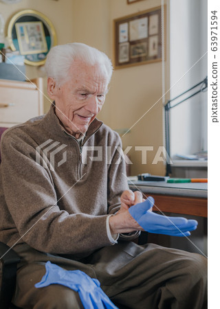 Old man wearing Protective Gloves against Covid-19 Old man wearing Protective Gloves against Covid-19 63971594