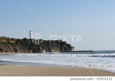 View of the sandy beach where you can see the lighthouse receiving the sunrise 63979112