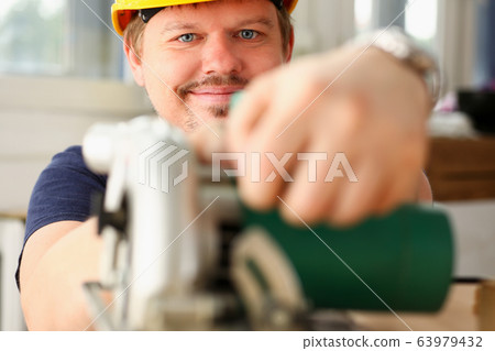 Worker using electric saw portrait 63979432