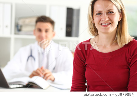 Satisfied happy beautiful smiling female patient with doctor Satisfied happy beautiful smiling female patient with doctor 63979894