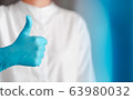 hand gesture of doctor wearing blue gloves, sign for good 63980032