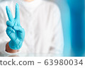 hand gesture of doctor wearing blue gloves, sign for fighting 63980034