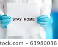 stay home to prevent covid-19 spread campaign, text on paper holding by doctor wearing blue gloves 63980036