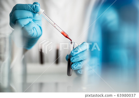 scientist holding blood test tube, lab testing for medication 63980037
