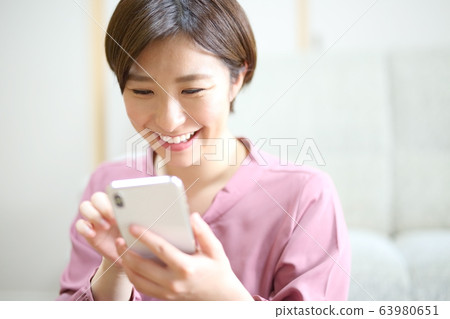 操作智能手機的女人的形象 63980651