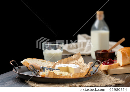 Rustic country breakfast with brie cheese, milk, baguette and cranberry jam 63980854