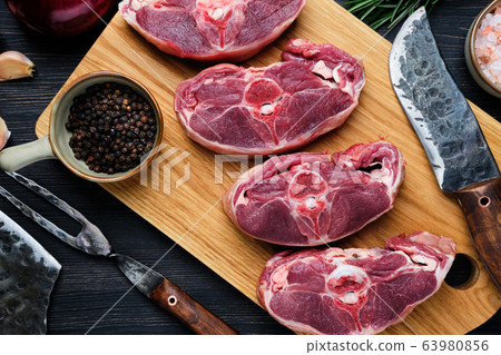 Overhead view of chopped fresh lamb shank on cutting board with spice 63980856
