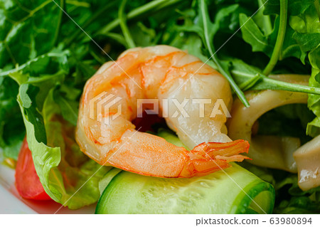 Macro photo of shrimp in salad with cucumber, arugula and pine nuts 63980894
