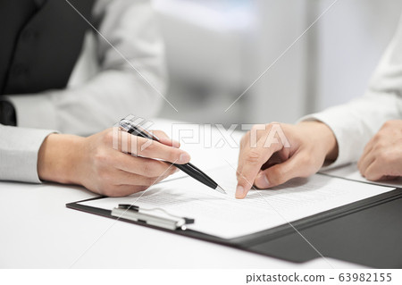 Japanese male businessman checking contents of contract Japanese male businessman checking contents of contract 63982155