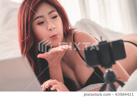 Woman with underwear using phone to boardcast Woman with underwear using phone to boardcast 63984421