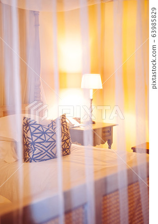 Contemporary hotel bedroom with wooden four poster bed Contemporary hotel bedroom with wooden four poster bed 63985829