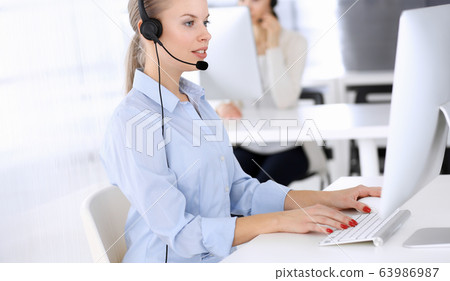 Call center. Group of operators working as customer service occupation.Beautiful woman receptionist in headset. Business people concept Call center. Group of operators working as customer service occupation.Beautiful woman receptionist in headset. Business people concept 63986987