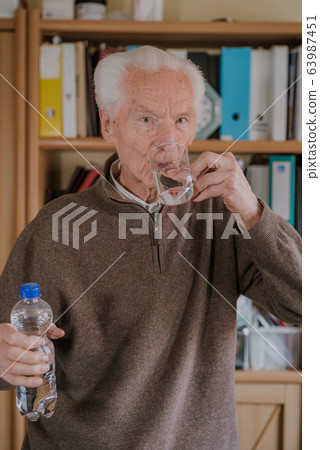 Portrait elderly man drinking water Portrait elderly man drinking water 63987451